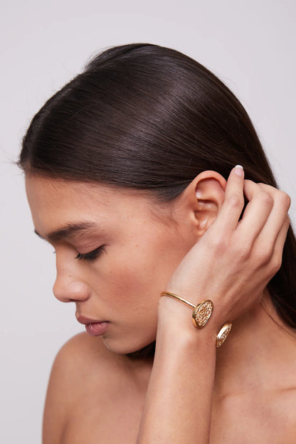 Minimalist and unique gold bracelet, showcasing a sleek and modern silhouette for versatile styling.